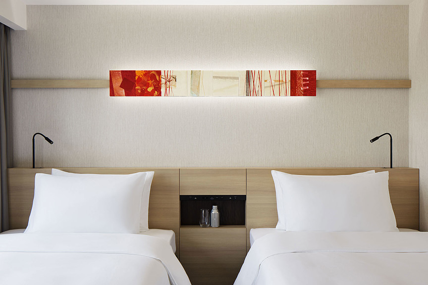 A room with white beds and a lamp.